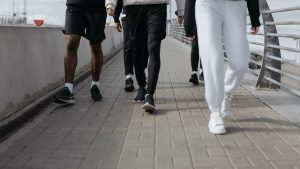 Casual group walk on a city sidewalk, showcasing modern fashion and footwear.