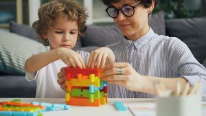 a woman and a child playing with a building set